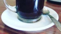 Ciri khas kopi kampung diseduh dalam gelas kaca dan diberi tatakan piring keramik kecil. Kopi dituang ke atas piring dan dihirup perlahan. Foto: Instagram @xionk.to