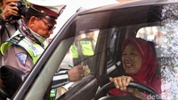 Polisi menilang para pengendara yang melanggar ganjil genap di Simpang Besar Matraman, Senin (9/9/2019).
