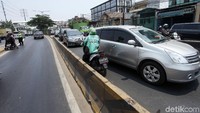 Seorang pengendara sepeda motor berusaha menghindari razia dengan melawan arus.