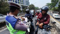 Polisi memeriksa kelengkapan surat pengendara yang nekat melintas di flyover Pesing.
