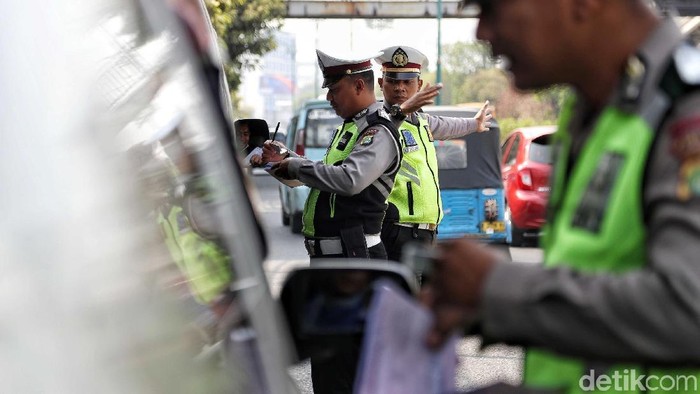 Penindakan Tilang Perluasan Ganjil Genap Sejumlah petugas Polisi Lalu Lintas (Polantas) melakukan tindakan penilaian terhadap mobil berplat genap di kawasan perluasan jalan ganjil genap, Simpang Besar Matraman, Jakarta, Senin (9/9). Penindakan tilang tersebut mulai diberlakukan pada hari ini (9/9) setelah pihak Kepolisian dan Dishub melakukan sosialisasi perluasan rasa jalan ganjil genap selama satu bulan. Masih banyak mobil yang ditilang pada hari ini dengan alasan tidak mengetahui perluasan ruas jalan ganjil genap.