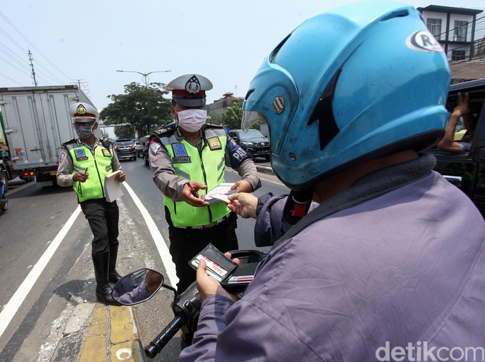 Sejumlah penegndara tengah mengantre untuk dikenakan sangsi tilang oleh kepolisian di Fly Over Pesing, Jakarta Barat, Senin (9/9/2019). Meski telah terpasang rambu-rambu para pengendara tetap nekat melanggar.