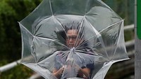 Badai Faxai membawa angin kencang yang disertai hujan. Warga yang beraktivitas di luar ruangan pun membawa payung untuk mengantisipasi hujan serta angin kencang imbas dari badai tersebut. Issei Kato/Reuters.
