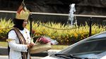 Dukung Revisi UU KPK, Massa Berpakaian Adat Bagikan Bunga