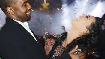 Rusak deh momen Kanye West dan Kim Kardashian di pesta pergantian tahun gegara ada yang ngintip di tengah. (Foto: Via Brightside)
