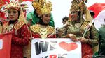 Dukung Revisi UU KPK, Massa Berpakaian Adat Bagikan Bunga