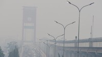 Asap tebal akibat kebakaran hutan dan lahan menyelimuti Jembatan Ampera, Palembang, Minggu (8/9/2019). 