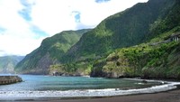 Pantai Seixal memiliki kontur yang landai dan berpasir hitam nan halus, dengan lautan biru (iStock)