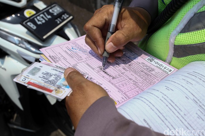 Sejumlah penegndara tengah mengantre untuk dikenakan sangsi tilang oleh kepolisian di Fly Over Pesing, Jakarta Barat, Senin (9/9/2019). Meski telah terpasang rambu-rambu para pengendara tetap nekat melanggar.