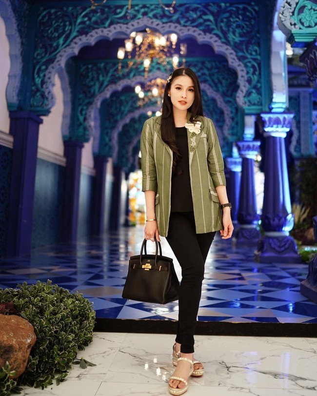 Menenteng tas Hermes Birkin, Sandra Dewi tampil stylish di usia kehamilan tujuh bulan dengan busana hitam yang dilengkapi dengan outer hijau garis-garis. Celana dan atasan serba hitam dengan padanan outer ini memang bisa menyamarkan perut bumil. Foto: Instagram @sandradewi88