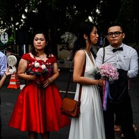 Ada juga beberapa pasangan yang memakai busana merah. Dalam budaya China, merah merupakan simbol keberuntungan dan kebahagiaan. Warna merah juga warna tradisional yang dikenakan pengantin China. Foto: Mohd RASFAN / AFP