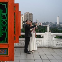 Pasangan pengantin yang baru saja mengikuti nikah massal di tanggal cantik 9-9-2019, berpose selfie di Thean Hou Temple. Lokasi pernikahan ini juga dikenal sebagai tempat wisata yang Instagramable. Foto: Mohd RASFAN / AFP