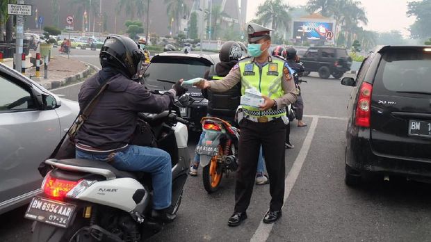 Asap Pekat Kepung Pekanbaru, Polantas Bagikan Masker ke Pengendara
