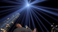 Seorang warga memotret Tribute in Light yang dinyalakan untuk memperingati peristiwa serangan 11 September 2001.