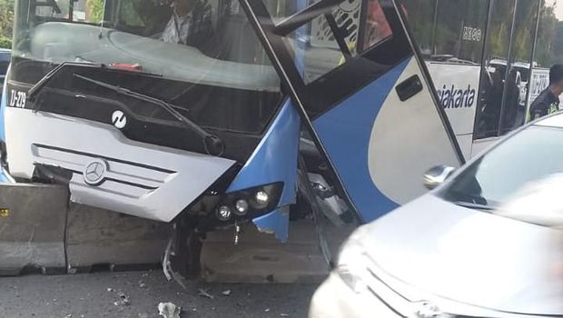 Bumper depan dan pintu bus Transjakarta hancur. 