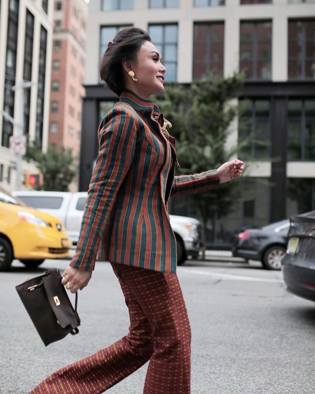 Yuni Shara memadukan busana lurik dan songket dengan tas Hermes Kelly ukuran mini. Penampilannya ini menarik atensi netizen yang sebagian besar memuji gaya stylishnya dengan kain Indonesia. Foto: Instagram @yunishara36