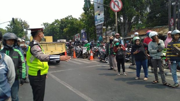 Pengendara berhenti untuk melihat iring-iringan jenazah.