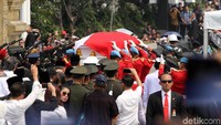 Peti jenazah BJ Habibie yang berbalut bendera merah putih digotong oleh 8 Paspampes menuju peristirahatan terakhir di TMP Kalibata.