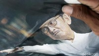 Salah seorang warga turut membawa serta potret mantan presiden Indonesia tersebut sebagai bentuk penghormatan terakhir jelang pemakaman BJ Habibie.