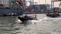 Sejumlah petugas menggunakan perahu untuk melakukan aksi bersih-bersih sampah plasti di laut kawasan Tanjung Priok.