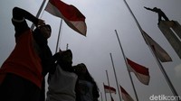 Sejumlah siswi memberikan penghormatan di depan jejeran bendera setengah tiang.