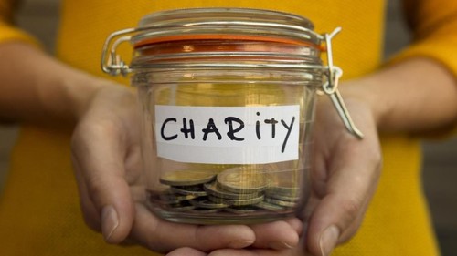 Woman collecting money for charity and holds jar with coins.