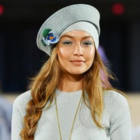 Tampil simpel dengan mini dress biru polos, Gigi melengkapi penampilannya dengan topi aksen bunga berwarna senada serta kalung statement. Sementara riasan wajahnya bernuansa nude dengan eyeshadow biru. Foto: Getty Images