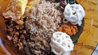 Menu yang ini namanya Nasi Palaparasa isiannya banyak banget. Ria melahap nasi ini bersama Aming. Duh sedapnya! Foto: instagram @riairawan