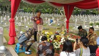 Ilham Habibie lalu menyiram batu nisan dan menabur bunga.