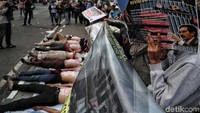 Kedelapan orang tersebut lantas berjejer. Di atas cat putih itu dituliskan satu huruf untuk satu orang. Tulisan itu lalu membentuk kalimat KPK No LSM.