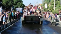 Karuan saja, kehadiran kendaraan tempur itu langsung menyita perhatian warga. Bukannya ngeri atau takut, warga malah langsung berbondong-bondong menyaksikan di tepian jalan raya.