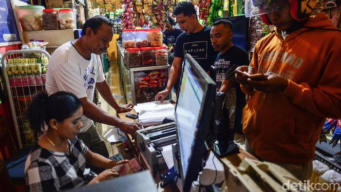 Agen BRI Link, Jusfri SZ Fangidae bersama istrinya melayani nasabah dan pembeli di warungnya di Baa, Rote, NTT, (22/8/2019). Keduanya menyatakan keuntungan yang diperoleh dari agen BRI Link sangat membantu usaha warung kelontong, rental PlayStation (PS) dan warung internet (warnet) yang digeluti.