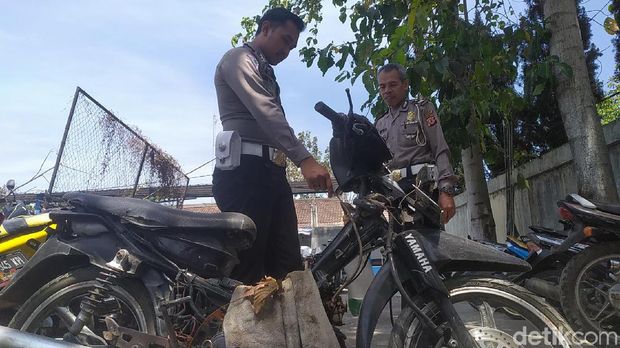 Polisi mengecek motor dengan tangki dari botol