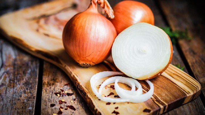Golden onions on rustic wooden background