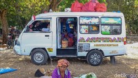 Seorang Emak-emak beristirahat disalah satu sisi mobil angkutan umum yang sedang menanti penumpang disalah satu sudut desa.