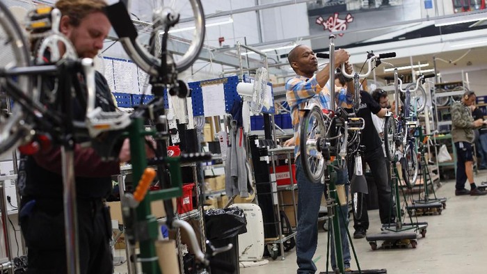 LONDON, ENGLAND - NOVEMBER 13:  Workmen assemble Brompton folding bicycles on the production line in their factory in Brentford on November 13, 2012 in London, England. Brompton is one of only two major bike frame manufacturers still based in the UK, creating all their folding bicycles in West London. The original Brompton patent was filed in 1979 by the inventor Andrew Ritchie and basic design remains largely unchanged. Each bike is comprised of over 1200 parts and takes approximately 6 hours to construct.  (Photo by Oli Scarff/Getty Images)