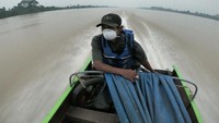 Pengemudi kapal cepat menyusuri Sungai Batanghari yang diselimuti kabut asap di Simpang, Berbak, Tanjungjabung Timur, Jambi, Sabtu (14/9/2019). Kabut asap akibat kebakaran hutan dan lahan (karhutla) di daerah itu telah mengganggu lalu lintas kapal karena membatasi jarak pandang. Foto: ANTARA FOTO/Wahdi Septiawan
