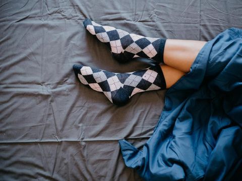 Woman's legs covered with blue sheet
