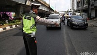 Sejumlah petugas polantas melakukan penindakan terhadap sejumlah pengendara roda empat yang melanggar ganjil genap di kawasan Kramat Raya, Jakarta, Senin (16/9/2019).