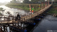 Sejumlah warga melintasi jembatan apung di Desa Bojongmalaka, Kecamatan Baleendah, Kabupaten Bandung, Senin (16/9/2019). 