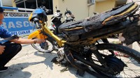 Motor Yamaha Vega itu hangus setengah. Rangka besi dan jok motor itu gosong akibat kobaran api.