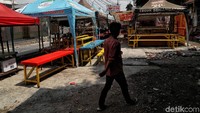 Tenda-tenda pedagang bergeser ke belakang.