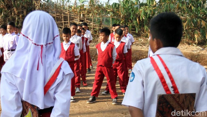 Siswa SDN Tanjung Biru, Kecamatan Majalaya di Kabupaten Bandung, mengikuti upacara bendera di kebun bambu. Pasalnya, sekolah mereka tak punya lapangan sendiri.