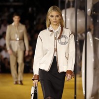Memeragakan koleksi Burberry Spring-Summer 2020, Kendall Jenner muncul dalam balutan jaket model bomber yang dihiasi detail kulit. Jaket tersebut berpadu apik dengan padanan kemeja dan rok berhiaskan fringe. (Foto: Tolga AKMEN / AFP)