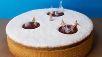 Kue Donat bertabur gula halus putih juga bisa dijadikan karya artistik. Dibentuk 3 lubang di atasnya yang memperlihatkan cokelat dan seakan-akan seperti kolam. Ditambah dengan miniatur manusia yang dipasang di samping lubang tersebut. Foto: Instagram @idolcidigulliver