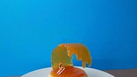 Dessert yang digunakan tidak melulu dari cookie. Karyanya yang satu ini terbuat dari pudding dengan topping madu. Madunya dibuat seolah seperti ombak pantai, lengkap dengan miniatur orang tengah berselancar. Foto: Instagram @idolcidigulliver