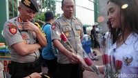 Polisi yang berjaga di depan gedung DPR juga mendapatkan bunga dari massa Aliansi Pemuda dan Mahasiswa Untuk Perbaikan KPK.