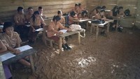 Murid-murid terlihat belajar di dalam kelas. Mereka duduk di kursi-kursi belakang meja kayu yang lapuk. Sepatu mereka kotor oleh lumpur. (Dok Yurisman Laia/SMA N 3 Huruna)