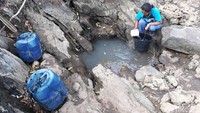 Seorang warga mengambil air dari rembesan pohon beringin di Dusun Duwet, Desa Purwodadi, Kecamatan Tepus, Kabupaten Gunungkidul, Selasa (17/9/2019).