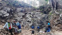 Beberapa warga beristirahat sejenak setelah bolak-balik mengambil air di rembesan pohon beringin tersebut.